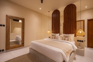 Un dormitorio moderno con una cama grande, dos lámparas de noche, un espejo y paneles de madera en las paredes.