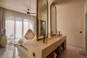Un baño moderno con un espejo grande, una bañera y un tocador con lavabo.