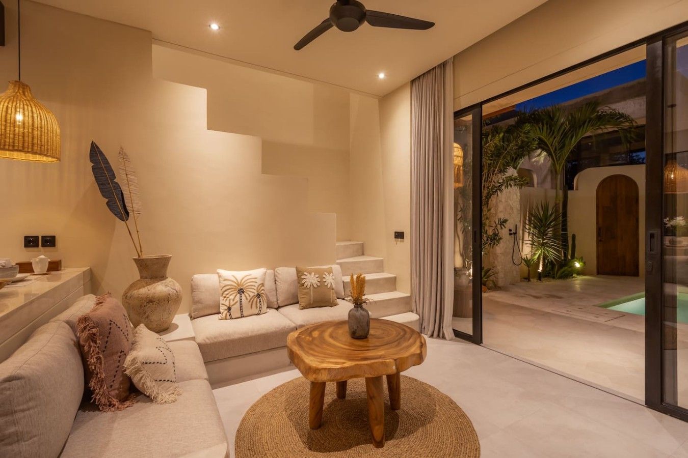 A modern living room with a sofa, a coffee table, and a staircase leading to a balcony.
