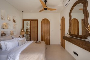 A bedroom with a bed, a ceiling fan, a large mirror, and wooden doors. - Roya 2BR Private Pool Villa w/ Jacuzzi in Bingin (Uluwatu)