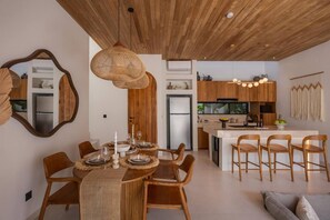 A modern kitchen with wooden cabinets, a central island, and pendant lighting. - Roya 2BR Private Pool Villa w/ Jacuzzi in Bingin (Uluwatu)