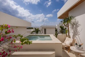 A modern outdoor pool area with a hot tub, lounge chairs, and potted plants. - Roya 2BR Private Pool Villa w/ Jacuzzi in Bingin (Uluwatu)