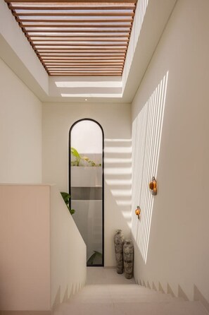A modern interior with a skylight, a staircase, and a wall-mounted light fixture. - Roya 2BR Private Pool Villa w/ Jacuzzi in Bingin (Uluwatu)