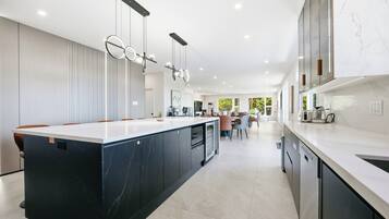 A modern kitchen with a central island, built-in appliances, and pendant lighting.