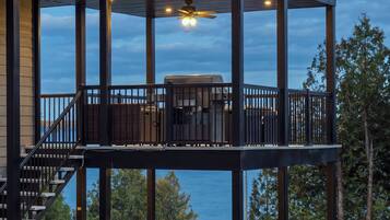 A multi-level outdoor deck with a covered seating area and a view of the water.