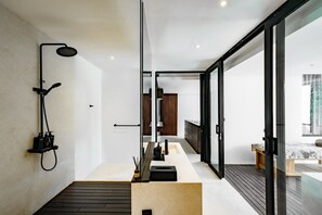 A modern bathroom with a shower, toilet, and sink. There is a wooden bench and a large window providing natural light. - Brezza 3BR Luxury Private Pool Villa - Uluwatu (South Kuta)