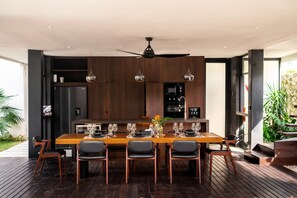 A modern dining area with a wooden table set for six, surrounded by chairs. - Brezza 3BR Luxury Private Pool Villa - Uluwatu (South Kuta)