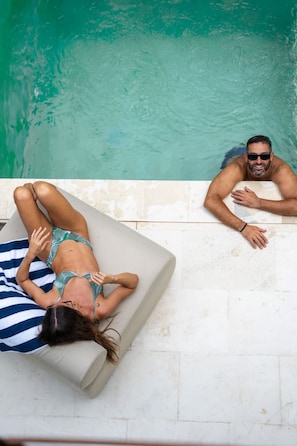 A poolside area with a lounge chair and a sun lounger. - Majo 1BR Romantic Villa, 3 Min to Thomas Beach (South Kuta)