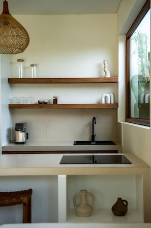 Eine moderne Küche mit integriertem Spülbecken, Holzböden und einer Pendelleuchte.
