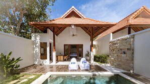 A modern villa with a swimming pool, outdoor seating, and a stone wall. - Parisula 1BR Villa with Pool in Bingin Uluwatu (South Kuta)