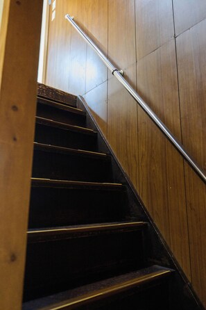 Un escalier en bois avec une rampe métallique.