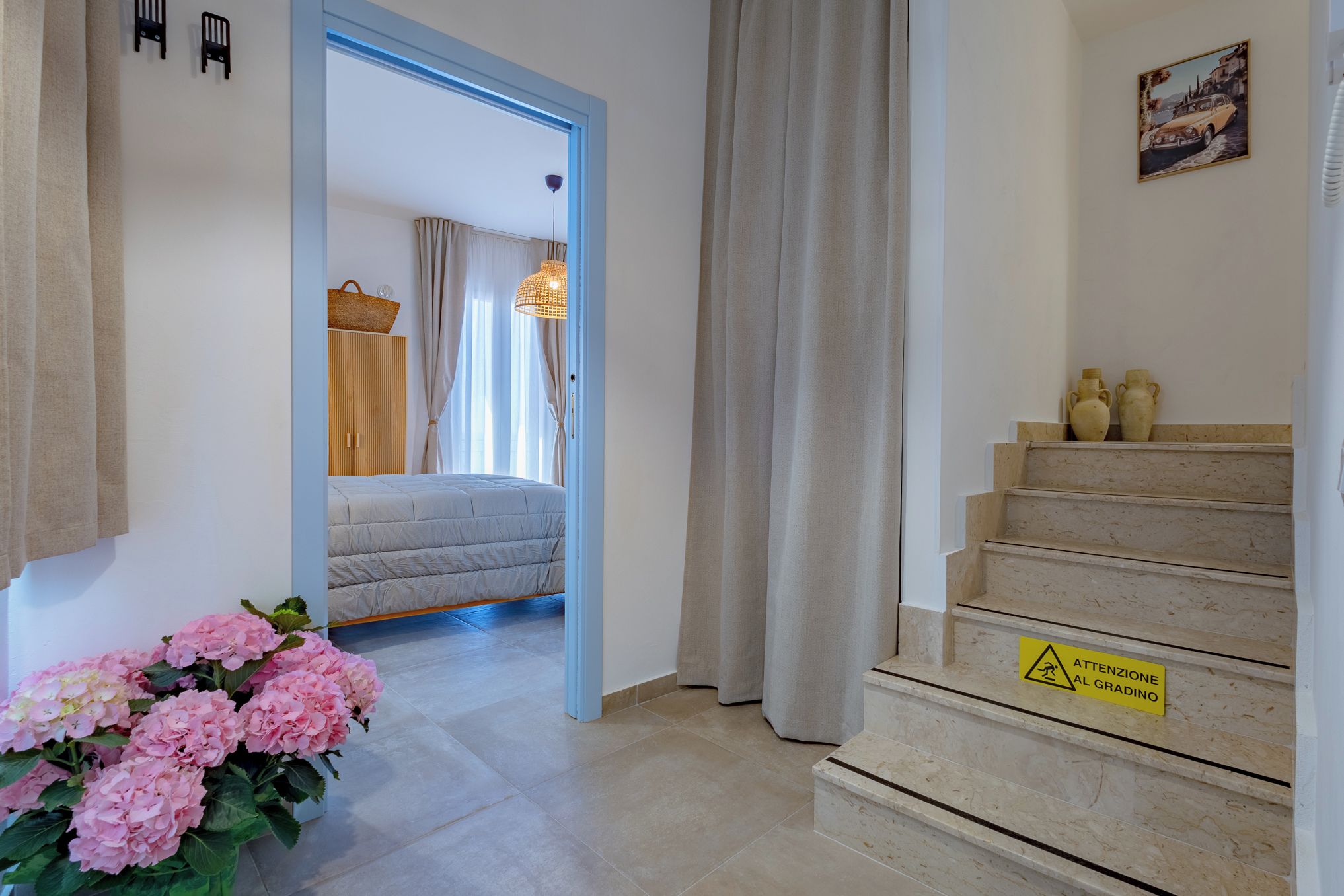 A hotel room with a bed, a staircase, and a caution sign.
