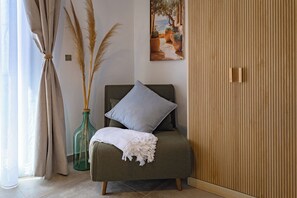 A room with a bed, a painting, a wooden wardrobe, and a vase with pampas grass. - New & Panoramic Harbor Views - Sanciolu House (Sciacca)