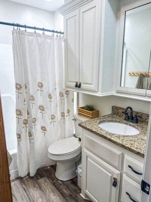 A bathroom with a toilet, sink, and cabinet. - ModWest Escape | Pets Welcome | Near I-40 & Rt 66 (Weatherford)