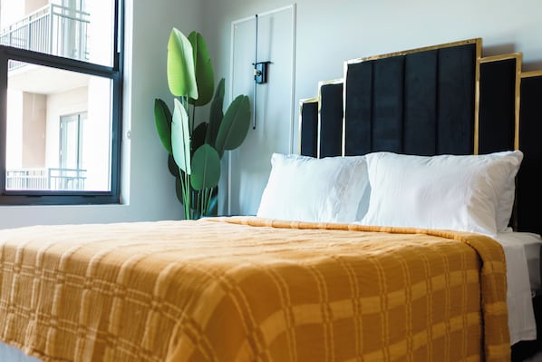 Une chambre d’hôtel avec un lit, une fenêtre et une plante.