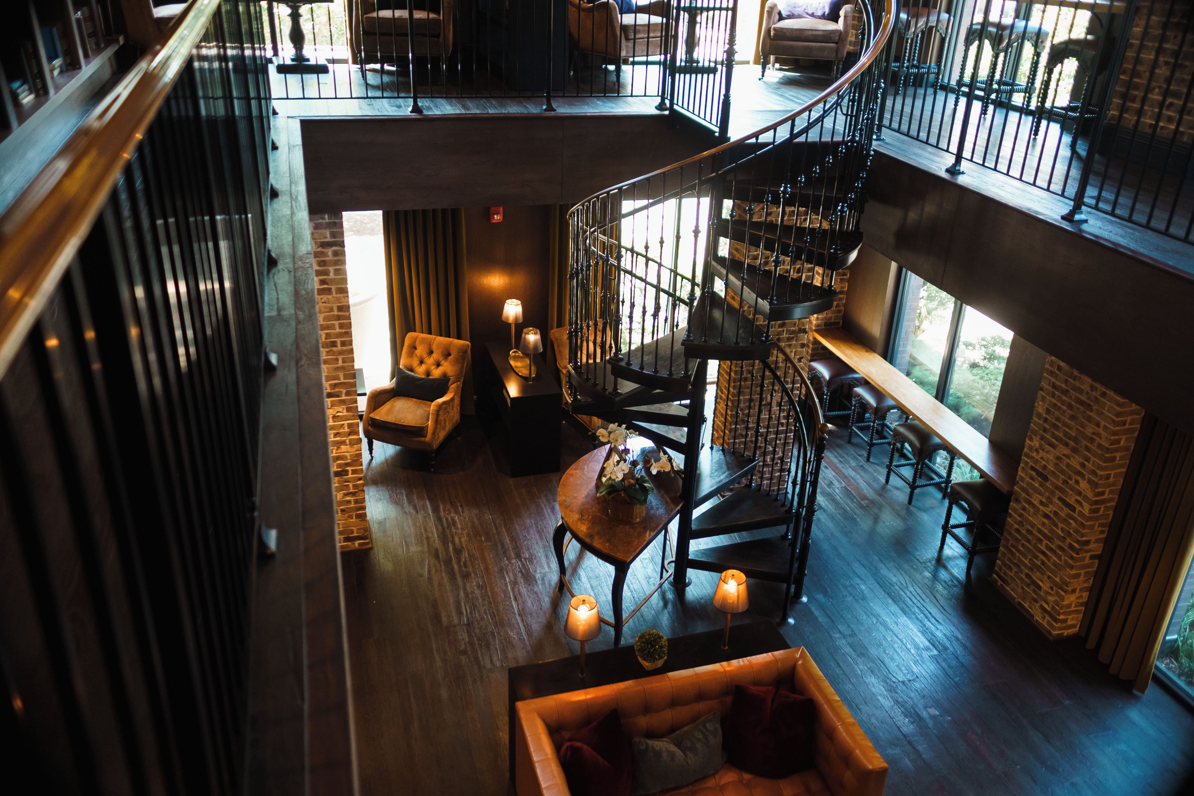 A multi-level interior with a spiral staircase, seating areas, and a view of the outdoors.