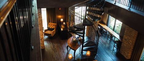 A multi-level interior with a spiral staircase, seating areas, and a view of the outdoors.