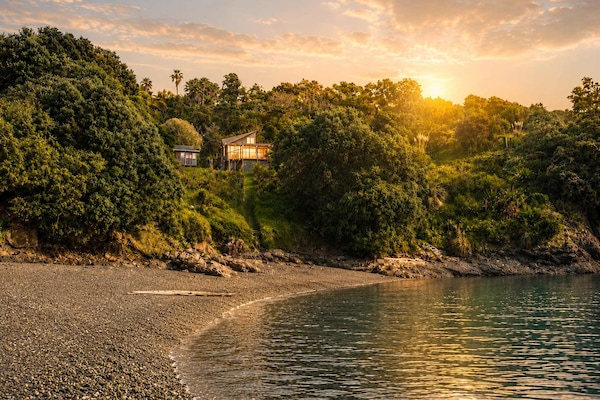 The property sits above Hekerua Bay and has direct access via a walkway and ladder