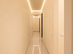 A corridor with a light-colored floor and walls, leading to a door at the end. - Central Georgetown Homestay for 8 Pax . Chulia Street, Penang (George Town)