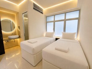 A modern hotel room with a large window, a round mirror, a sink, and two beds. - Central Georgetown Homestay for 8 Pax . Chulia Street, Penang (George Town)