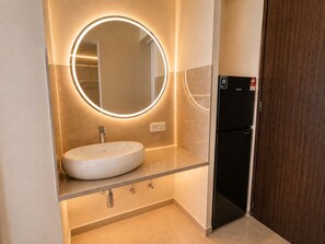 A modern bathroom with a round mirror, a white sink, and a black refrigerator. - Central Georgetown Homestay for 8 Pax . Chulia Street, Penang (George Town)