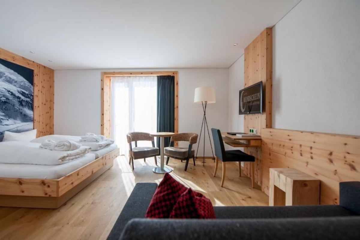 Une chambre d’hôtel avec un lit, un bureau, une chaise et un canapé.