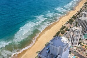 A coastal hotel with a beachfront view, a pool, and a parking area. - OceanDreams Lvl 46 2BR Skyhome | 2 Pools & Gym (Surfers Paradise)