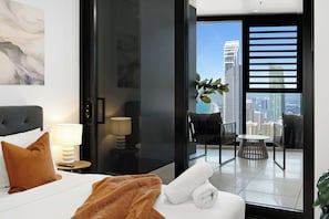 Bedroom with Private Balcony Access
Wake up to bright natural light and city vistas right from your plush bed. Sliding glass doors lead straight out to a private balcony seating area. - OceanDreams Lvl 46 2BR Skyhome | 2 Pools & Gym (Surfers Paradise)