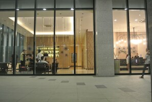 Eine Hotelhalle mit einer Rezeption, einer Sitzecke und einer Treppe zu den oberen Etagen.