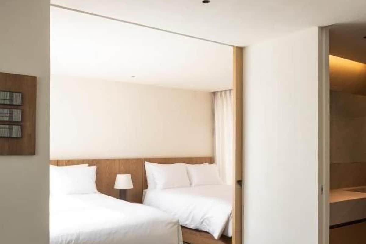 Quarto de hotel com cama, mesa de cabeceira e uma cadeira.