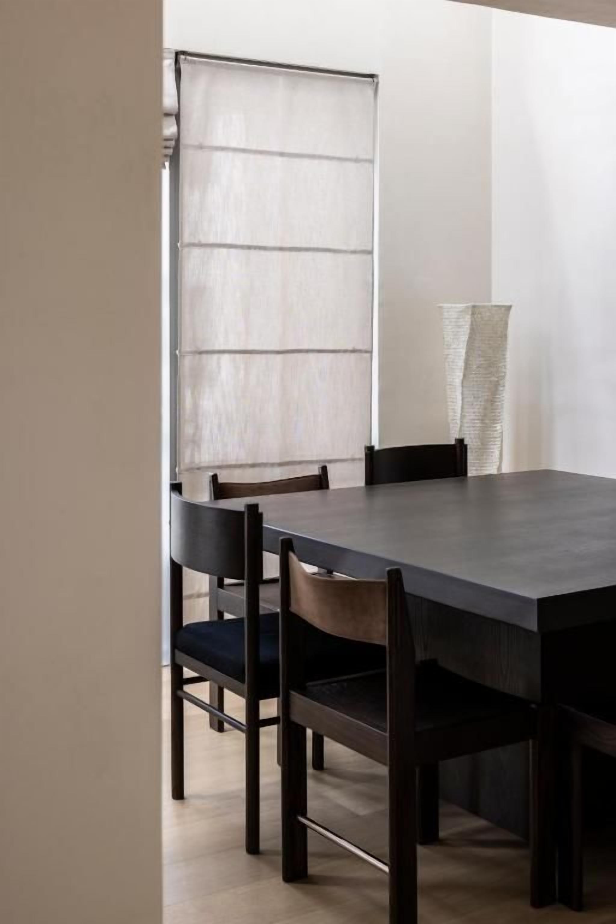 Un comedor con una mesa rectangular y cuatro sillas.