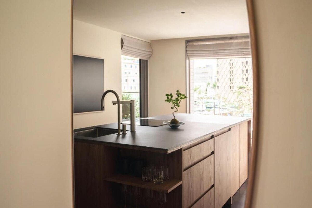 Cocina moderna con encimera de madera, un lavamanos y una planta en maceta.