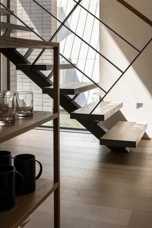 A modern staircase with a geometric design, leading to a landing area with a white surface.