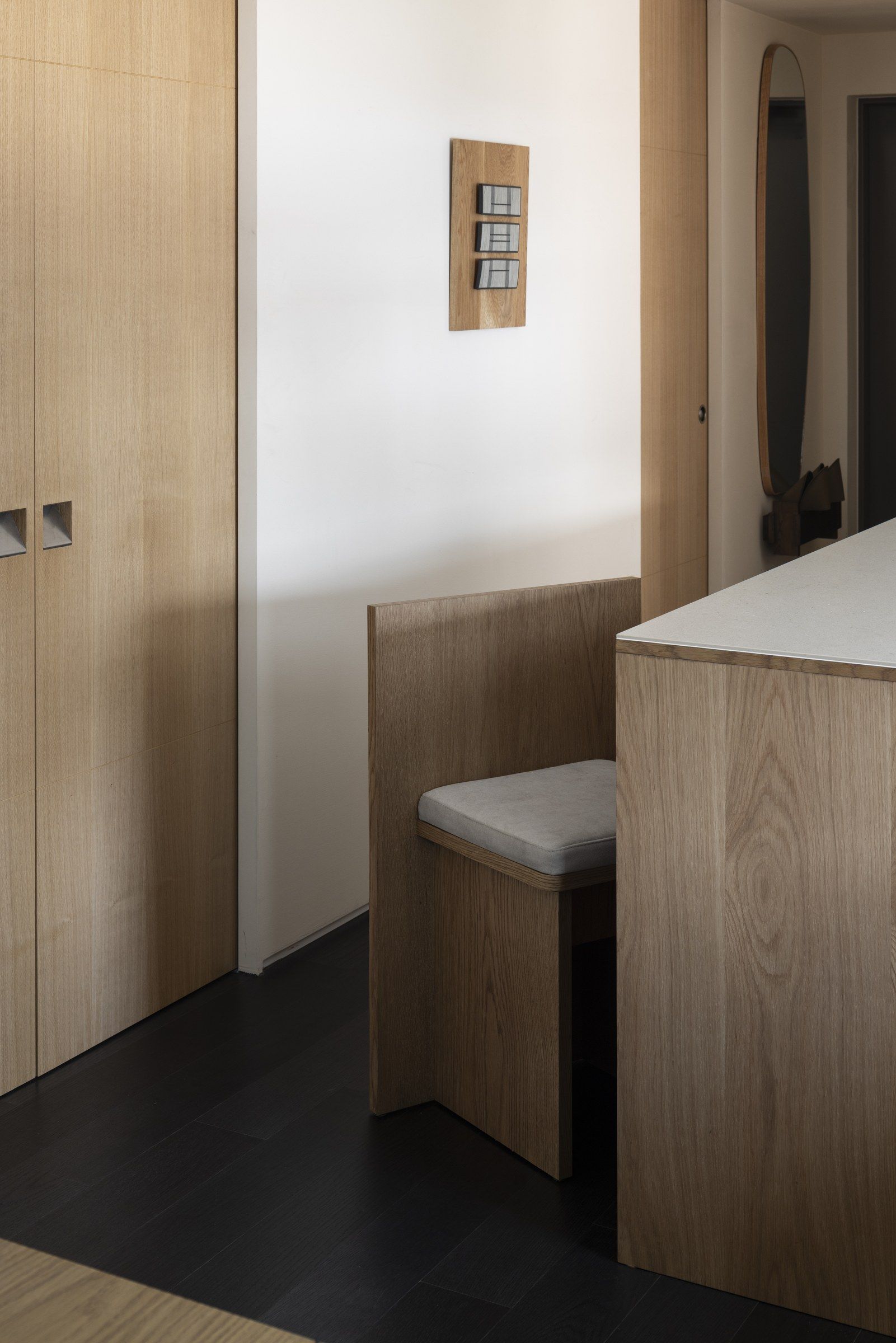 A modern kitchen with wooden cabinetry, a built-in bench, and a countertop.