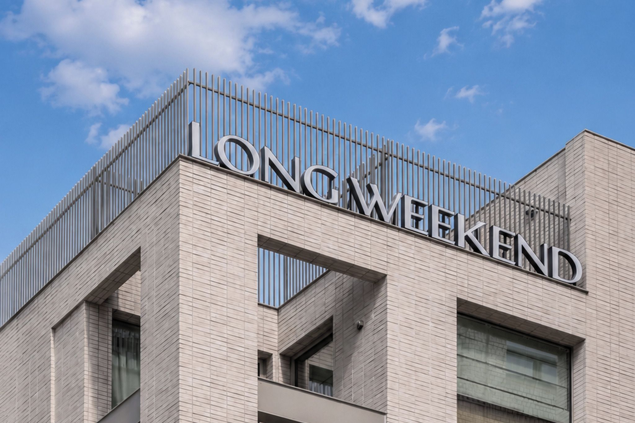Un edificio con un diseño arquitectónico moderno, que presenta un letrero destacado que dice 'LONGMEKEND'.