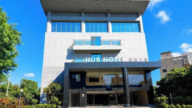 A modern hotel with a prominent entrance, large windows, and a clear sky. - Hub Hotel Chiayi (Chiayi)