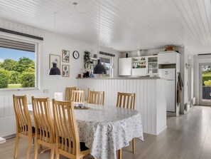 A dining area with a round table, wooden chairs, and pendant lights. - "Efrosina" - 600m from the sea by Interhome (Hejls)