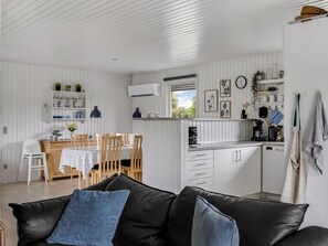 A compact living space with a dining area, kitchenette, and a sofa with cushions. - "Efrosina" - 600m from the sea by Interhome (Hejls)