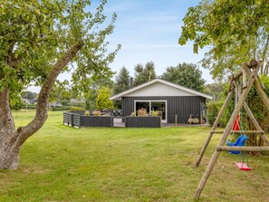 Een huis met een garage, een schommel en een gazon.