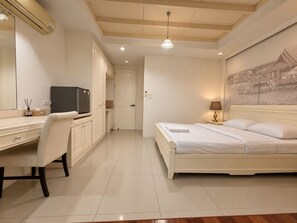 A hotel room with a bed, a desk, a television, and a painting on the wall. - Sukhum MRT Sutthisan (Bangkok)