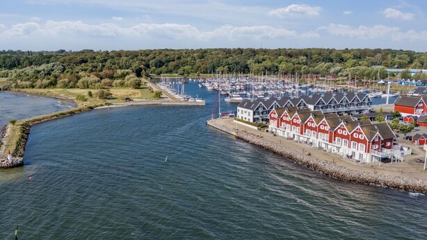 A marina with red houses, boats, and a calm water body. - "Loan" - 10m to the fjord by Interhome (Nykøbing Sj)