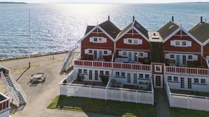 A coastal property with a two-story main building, a white picket fence, and a paved driveway. - "Loan" - 10m to the fjord by Interhome (Nykøbing Sj)