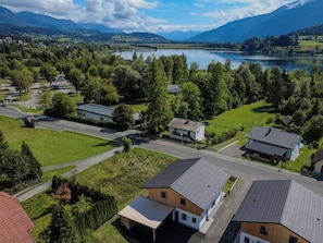 Un área residencial con casas, una carretera y un lago rodeado de montañas.