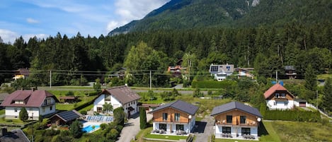 A residential area with houses, a swimming pool, and a mountain backdrop.
