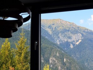 Vista de la montaña a través de una ventana con puerta y lámpara de techo.