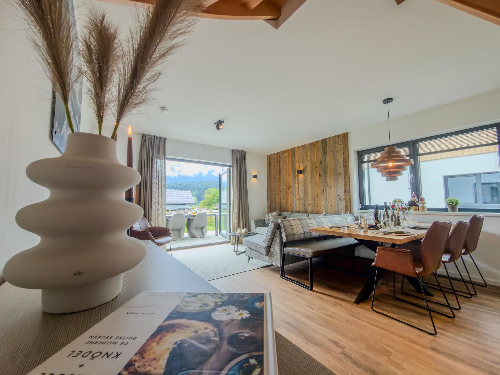 Ein moderner Essbereich mit Holztisch, Stühlen und Blick ins Freie.