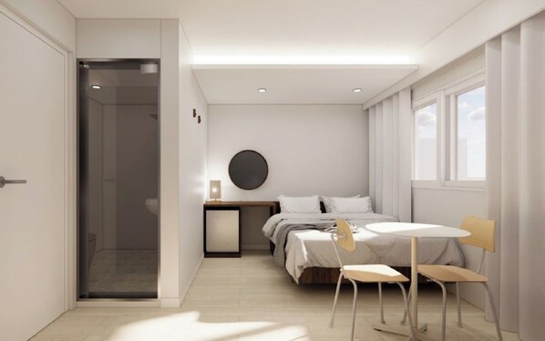 Un dormitorio moderno con cama, mesita de noche, lámpara y una pequeña mesa con sillas.