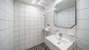A bathroom with white tiles, a white sink, a mirror, and a shower. - Incheon Bupyeong Chosunjang (Incheon)