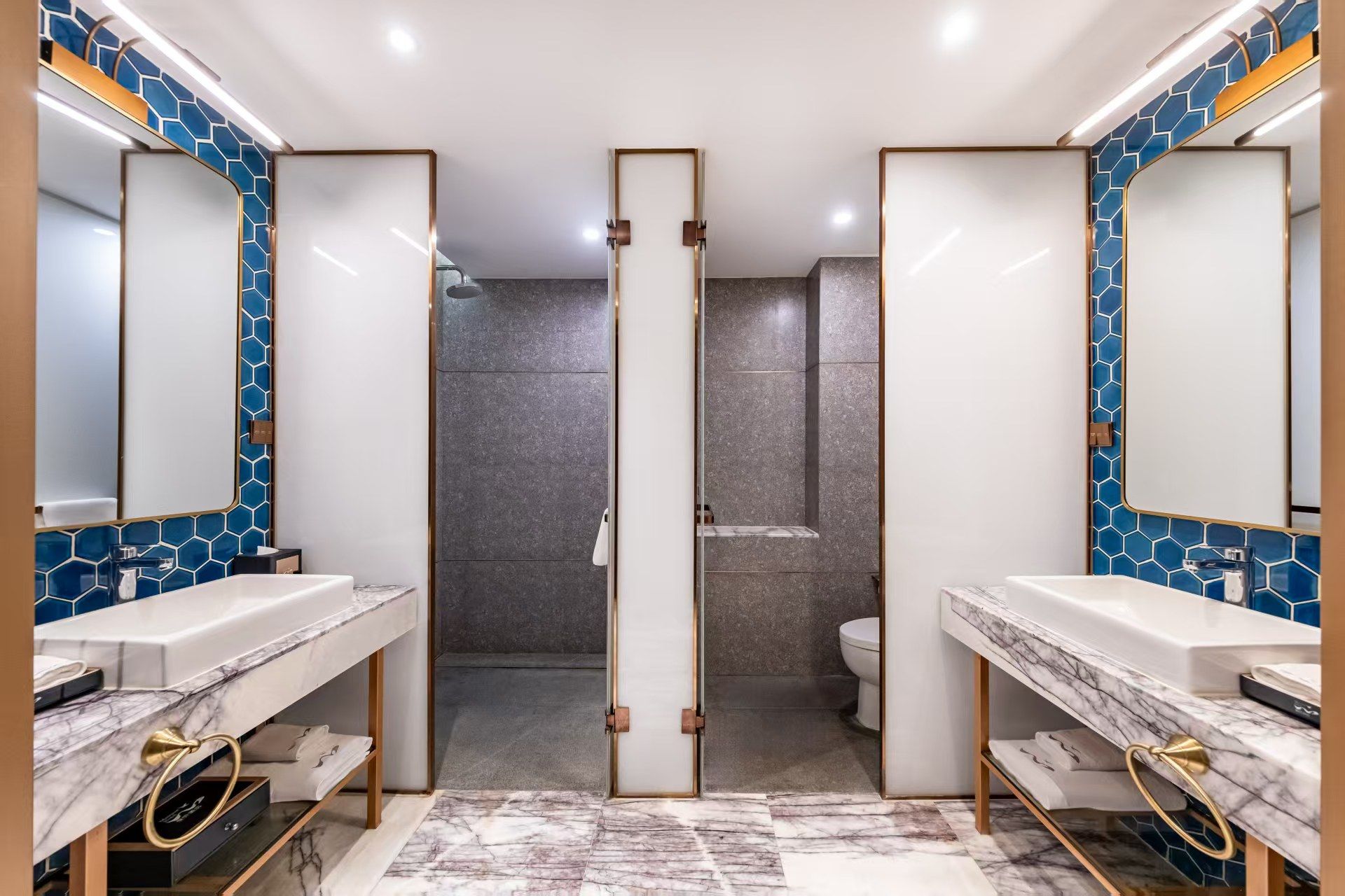 A modern bathroom with two sinks, a shower area, and a mirror.