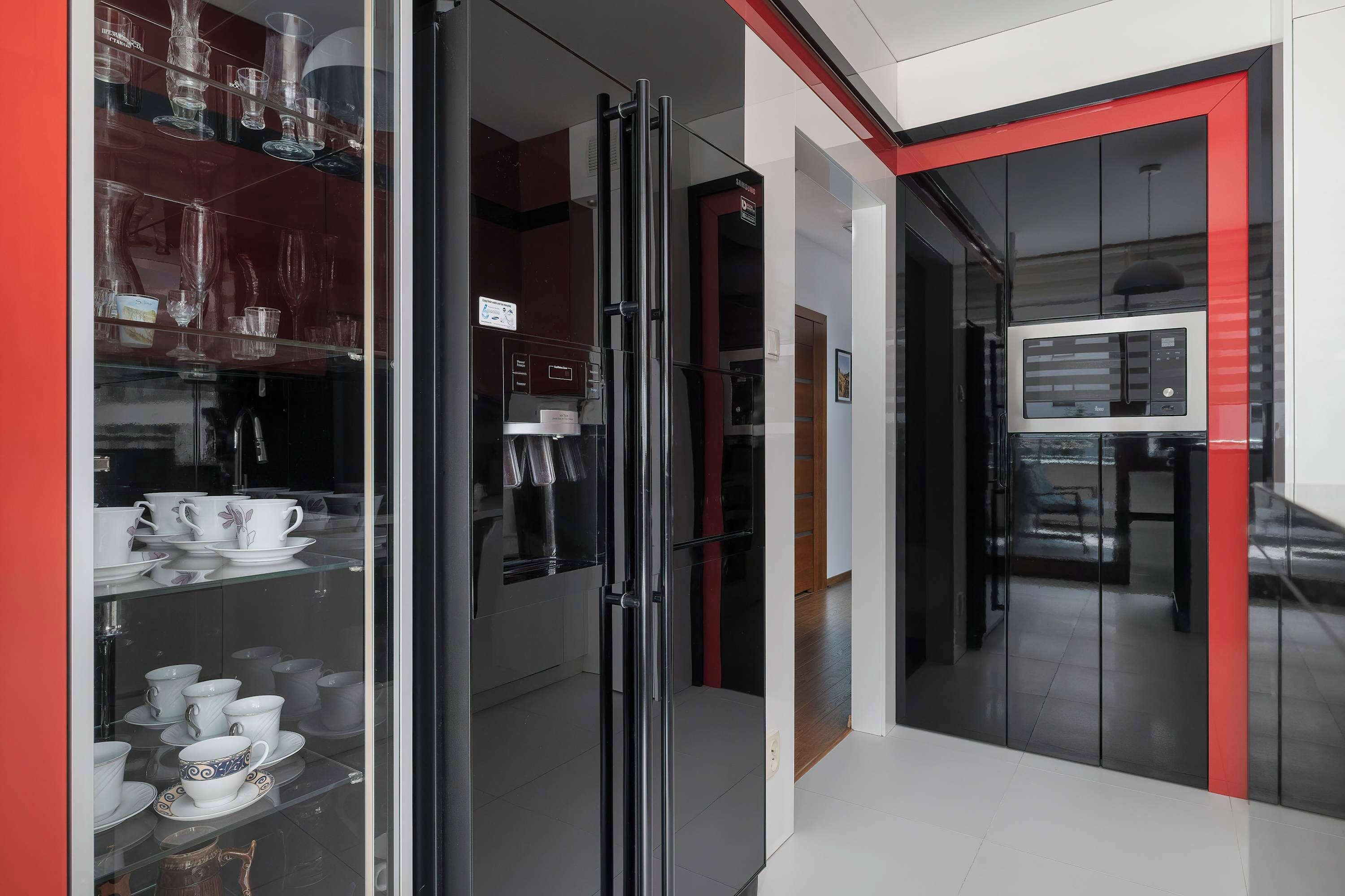 Uma cozinha moderna com geladeira de porta de vidro, micro-ondas e forno Samsung.